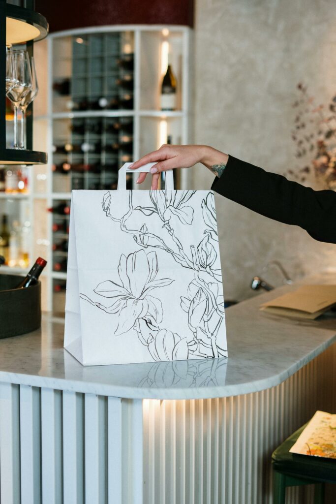 Person Holding White and Black Floral Paper